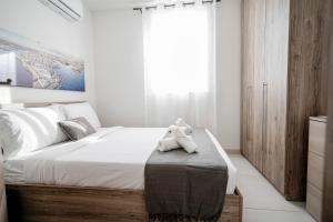 a bedroom with a bed with a teddy bear on a ottoman at Central Penthouse with massive terrace in San Ġwann