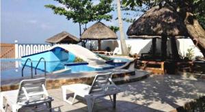 a swimming pool with two chairs and a slide at AGM Beachfront Resort in Donsol