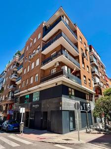 a tall brick building with a car parked in front of it at Hotelito Boutique Madrid Auditorio in Madrid