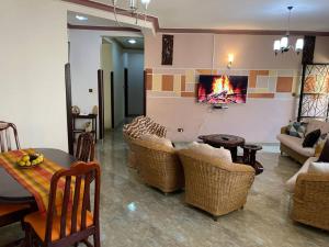 a living room with a couch and chairs and a table at Mukisa Apartments in Kampala