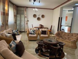 a living room with couches and chairs and a table at Mukisa Apartments in Kampala +1 photo