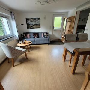 a living room with a blue couch and a table at Ferienwohnung Auszeit in Hohnstein +7 photos