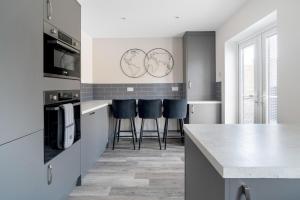 a kitchen with a counter and three bar stools at Perfect Getaway 1 in Middlesbrough