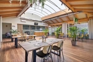 a dining room with tables and chairs and a glass ceiling at Pardavila 57 Slow Hotel in Marín