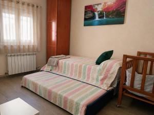 a small bedroom with a bed with a striped blanket at GR - Polvorín Oasis in Valladolid