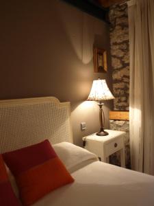a bedroom with a bed and a lamp on a night stand at Posada El Salin in Muñorrodero +24 photos