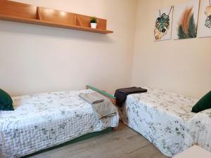 a bedroom with two beds and a shelf at GR - Polvorín Oasis in Valladolid +8 photos