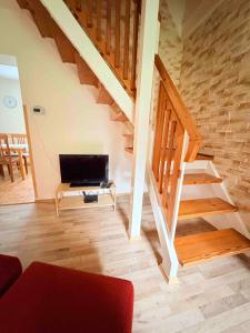 a living room with a staircase and a couch at Chalupa v Beskydech in Trojanovice