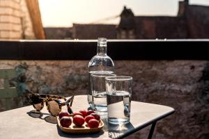 a bottle of water and a bowl of fruit on a table at Auberge du Mouton in Porrentruy +20 photos