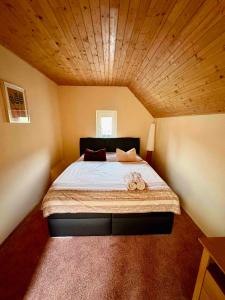 a bedroom with a large bed with a wooden ceiling at Chalupa v Beskydech in Trojanovice
