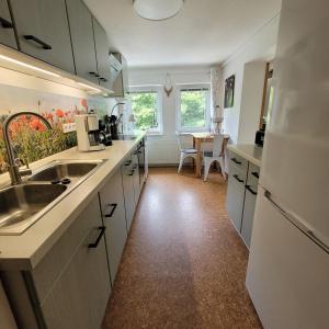 a kitchen with white cabinets and a sink and a table at Ferienwohnung Auszeit in Hohnstein
