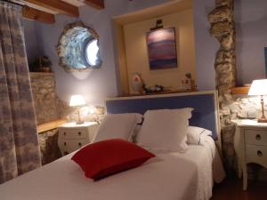 a bedroom with a bed with a red pillow on it at Posada El Salin in Muñorrodero