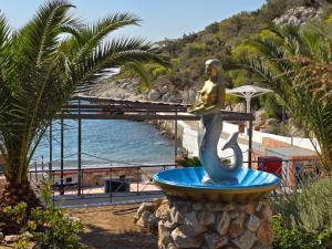 a statue of a mermaid in a fountain next to the ocean at Garden Room with Private Patio Salamis in Eantio