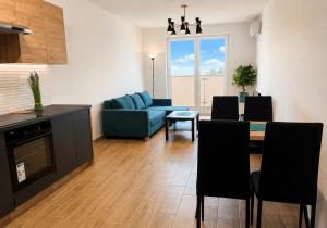 a living room with a blue couch and a table at Apartament Dolina Baryczy in Żmigród +5 photos