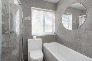 a bathroom with a toilet and a shower and a mirror at Perfect Getaway 1 in Middlesbrough +14 photos