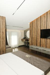 a bedroom with a bed and a tv on a wall at Xhasen Hotel & Café in Tirana