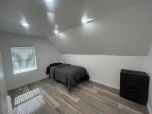 a bedroom with a bed and a dresser in it at Loft Apartment by the River Fort Edward in Fort Edward