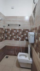 a bathroom with a toilet with a phone next to it at Radhe Krishna Guest House in Srīrangam