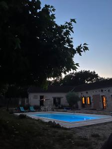 a swimming pool in front of a house at La Perle Rare in La Barthe