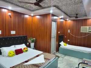 a hotel room with two beds and a table at T & G Guest House in Patna