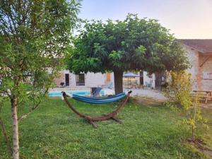 a blue hammock in a yard next to a tree at La Perle Rare in La Barthe