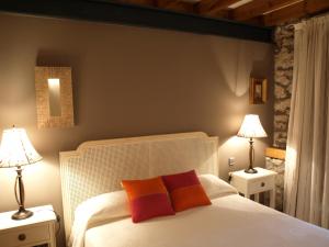 a bedroom with a white bed with two lamps at Posada El Salin in Muñorrodero
