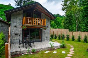 a house with a balcony and a table in a yard at Dolana Wadi Taş Evleri in Pirinçlik +86 photos