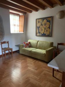 a living room with a green couch and a table at Mirella house Desenzano del Garda -Centro storico, 30 mt dal lago in Desenzano del Garda