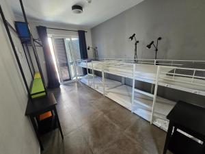 a room with two beds and a table and a desk at SUBTUB Hostel Makarska in Makarska