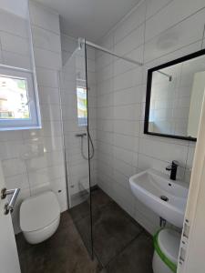 a bathroom with a toilet and a sink and a shower at SUBTUB Hostel Makarska in Makarska