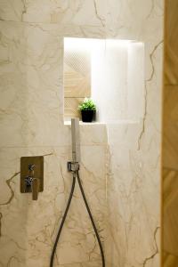 a bathroom with a mirror and a plant on a wall at Xhasen Hotel & Café in Tirana +89 photos