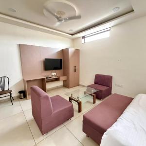 a room with a bed and a couch and a tv at City Palace Sagar in Sāgar