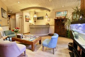 uma sala de estar com uma mesa e cadeiras e um aquário em Hotel des Abers em Saint Malo