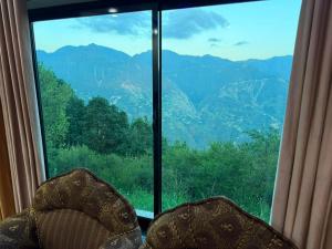 a chair in front of a large window at Galiyat Peak in Abbottabad