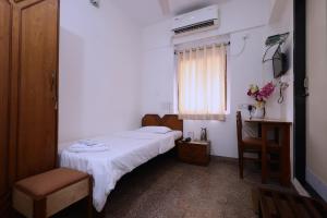 a small room with a bed and a window at YWCA International Centre in Mumbai