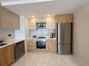 a kitchen with wooden cabinets and a stainless steel refrigerator at Dalaman Airport Suite 11 in Dalaman