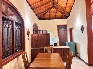 a dining room with a wooden table and chairs at Johannes Nest in Gampola