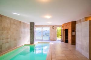 a swimming pool in a house with a tile hallway at AH-Corso Wellness Residence in Siófok