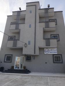 a building with a sign on the side of it at Midtown Appart Hôtel in Nouadhibou