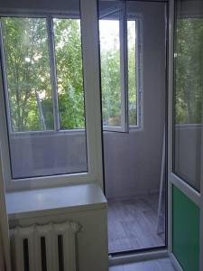 an empty room with two windows and a radiator at Жаркын in Naryn
