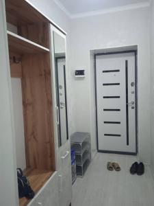 a room with a closet with a mirror and shoes at Жаркын in Naryn