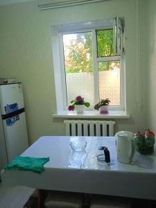 a kitchen with a white table and a window at Жаркын in Naryn