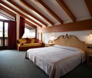 a bedroom with a large bed and a couch at Hotel Castel Pietra in Fiera di Primiero