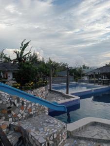 a swimming pool with a blue slide in a resort at Bregil Villas in Pagudpud