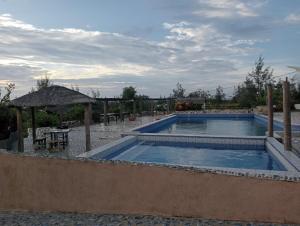 a swimming pool with a table and an umbrella at Bregil Villas in Pagudpud