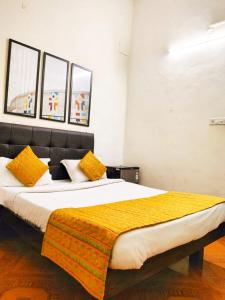 a bedroom with a large bed with yellow pillows at Baga Beach Way in Baga
