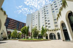 a large white building with trees in front of it at MaisonNova Deluxe 2 in Tirana