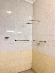 a bathroom with a shower with tan and white tiles at Johannes Nest in Gampola
