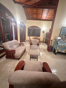 a living room with couches and chairs in a room at Johannes Nest in Gampola