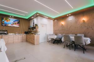 a dining room with tables and chairs and a kitchen at APART-HOTEL PRESiDENT 2 in Ulcinj